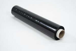 A roll of Pallet Wrap - Black with a white cardboard core is placed on a white surface.