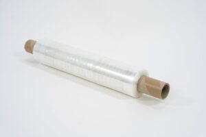 A roll of Pallet Wrap – Clear with brown cardboard tubes at both ends is placed diagonally on a white surface.