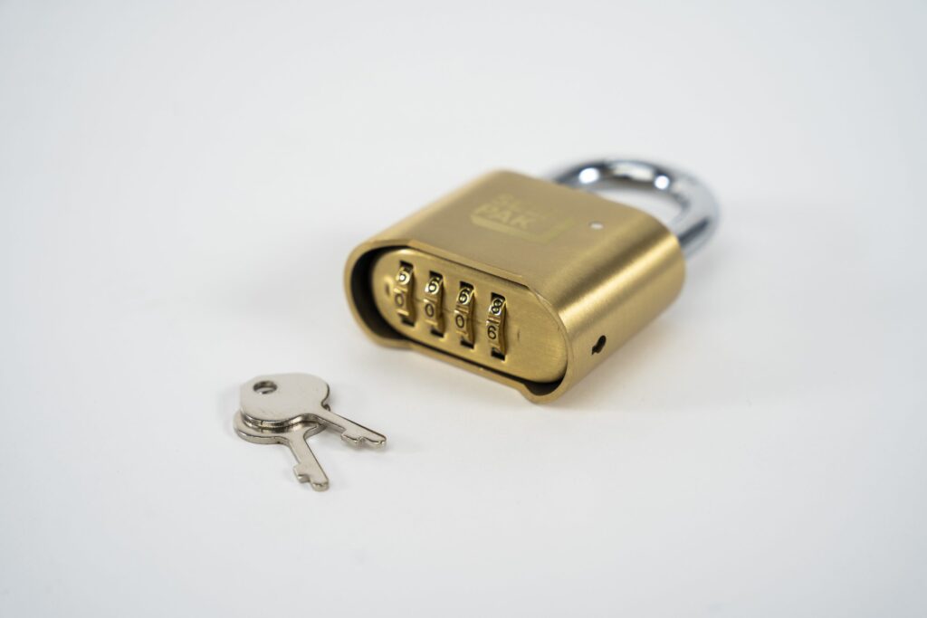 The padlock's combination rests with its dials in view beside two silver keys on a white background, highlighting the security and versatility of modern combination locks.
