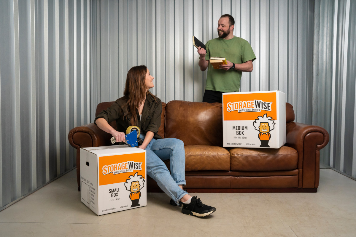 a couple sitting with the personal belongings in a self storage storage unit