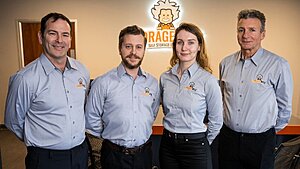 The StorageWise Self Storage Story: Four Generations of Self-Storage Expertise in Limerick 4 Four people in matching light grey shirts with the StorageWise self storage logo stand side by side, smiling, in an office in Limerick with the company’s lion logo and name displayed on the wall behind them.